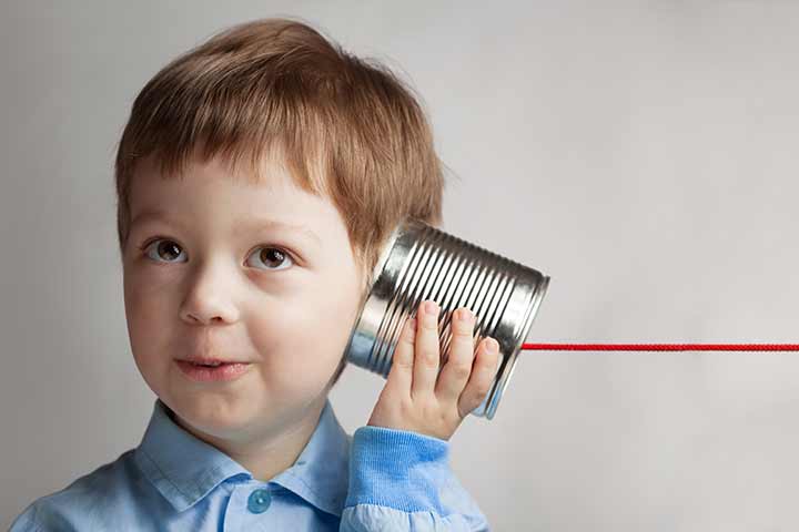 Junge mit Dosentelefon am Ohr